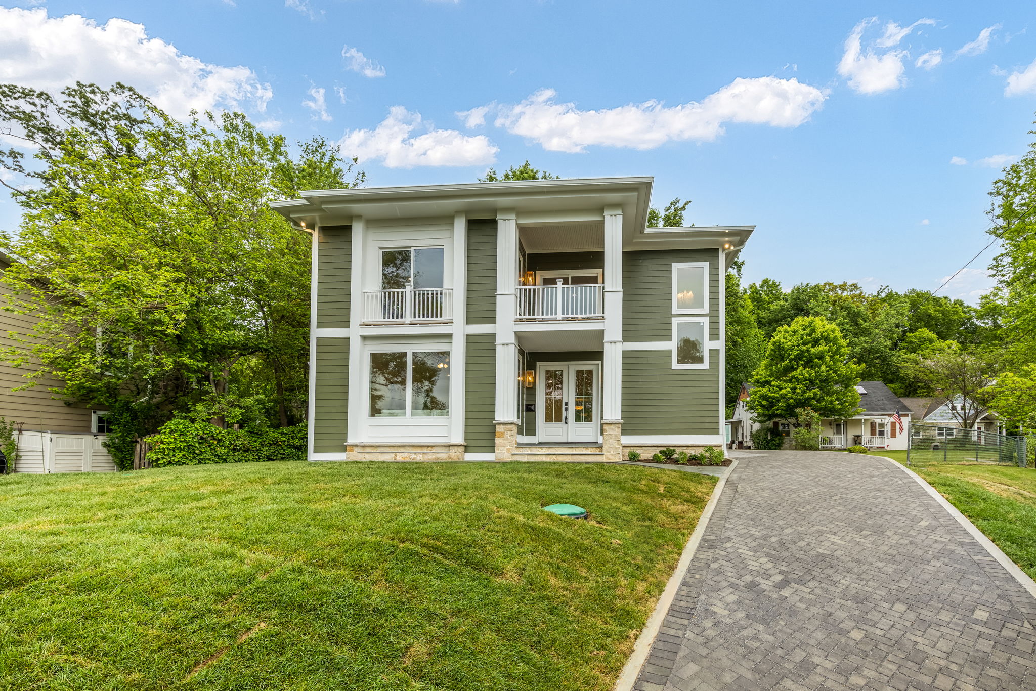 Front of the home with paver driveway and detached garage